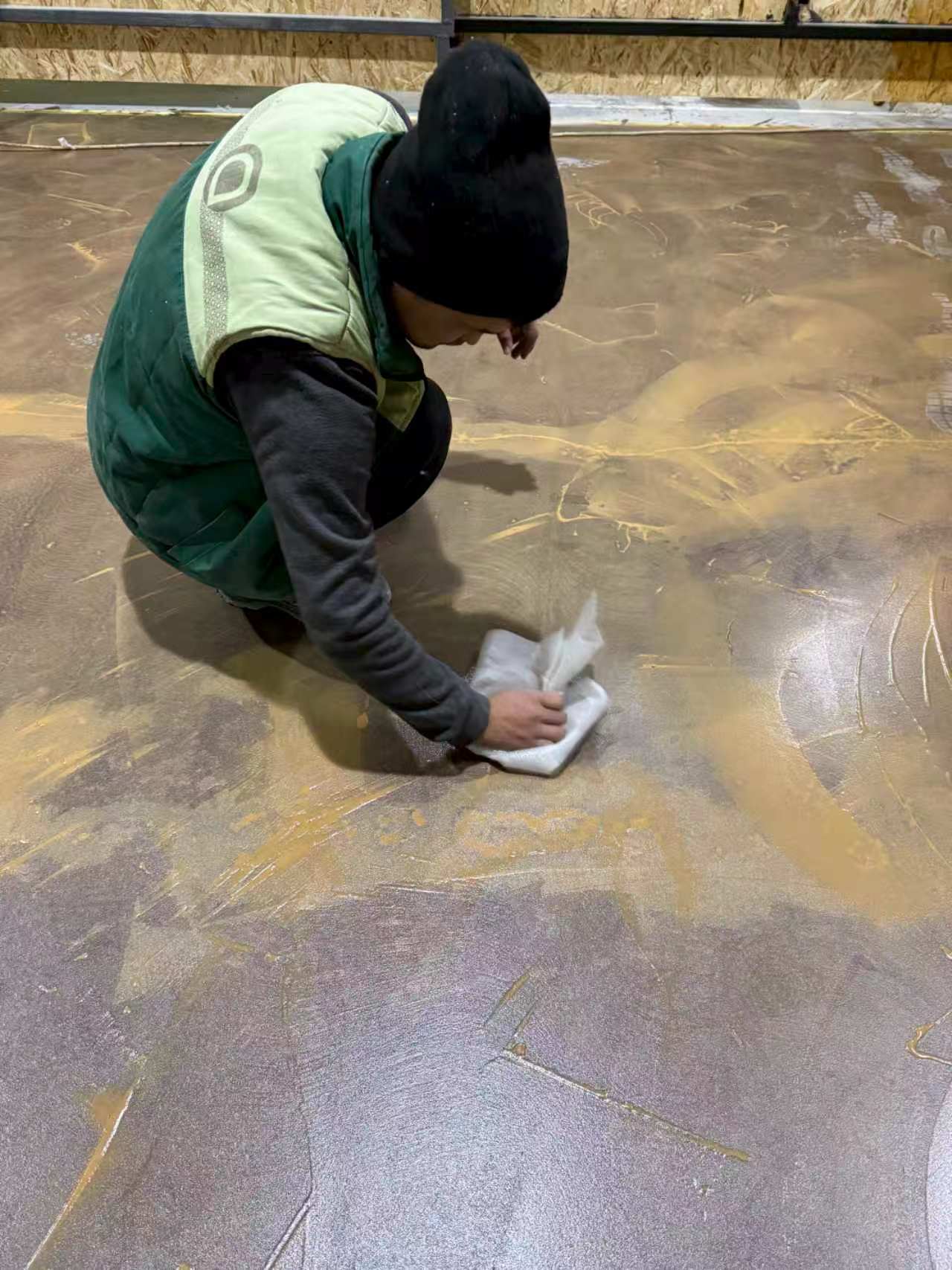Industrial floor substrate experiencing chemical erosion and deep discoloration from forklift battery acid and oil spills