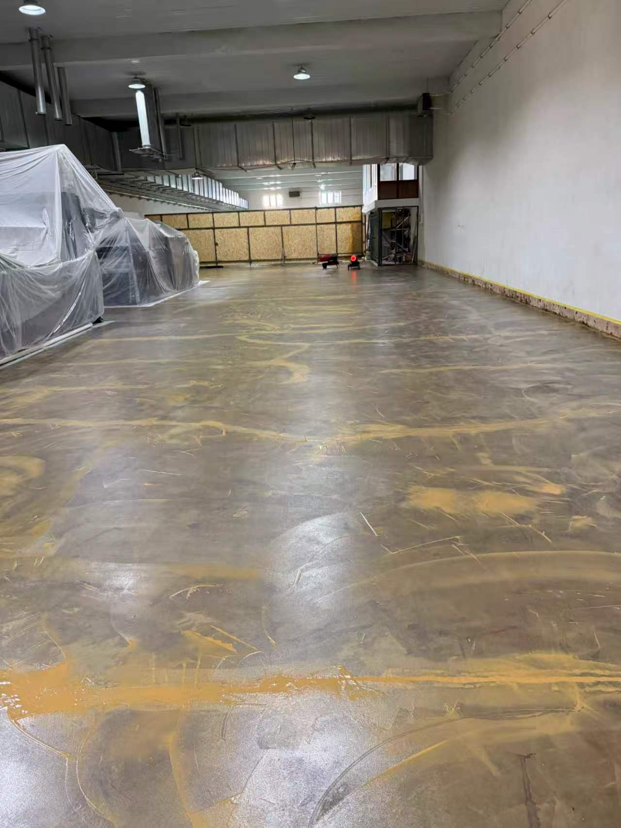 Pitted and rough industrial floor surface trapping grime and requiring intensive cleaning maintenance