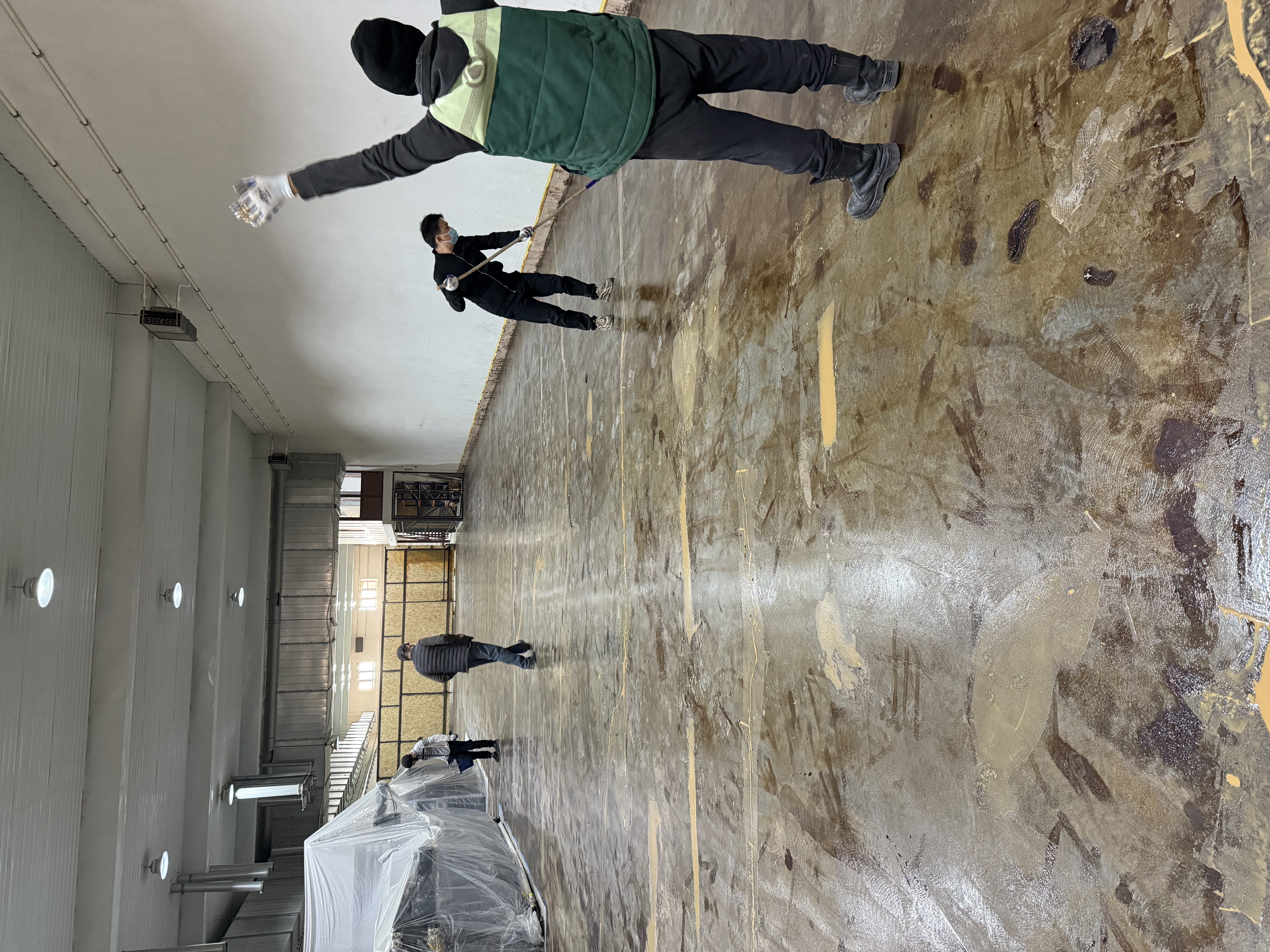 Application of high-penetration epoxy sealing primer using a roller on prepped concrete